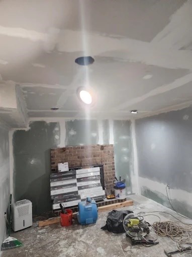 Taped drywall and a dehumidifier mid-restoration in a basement