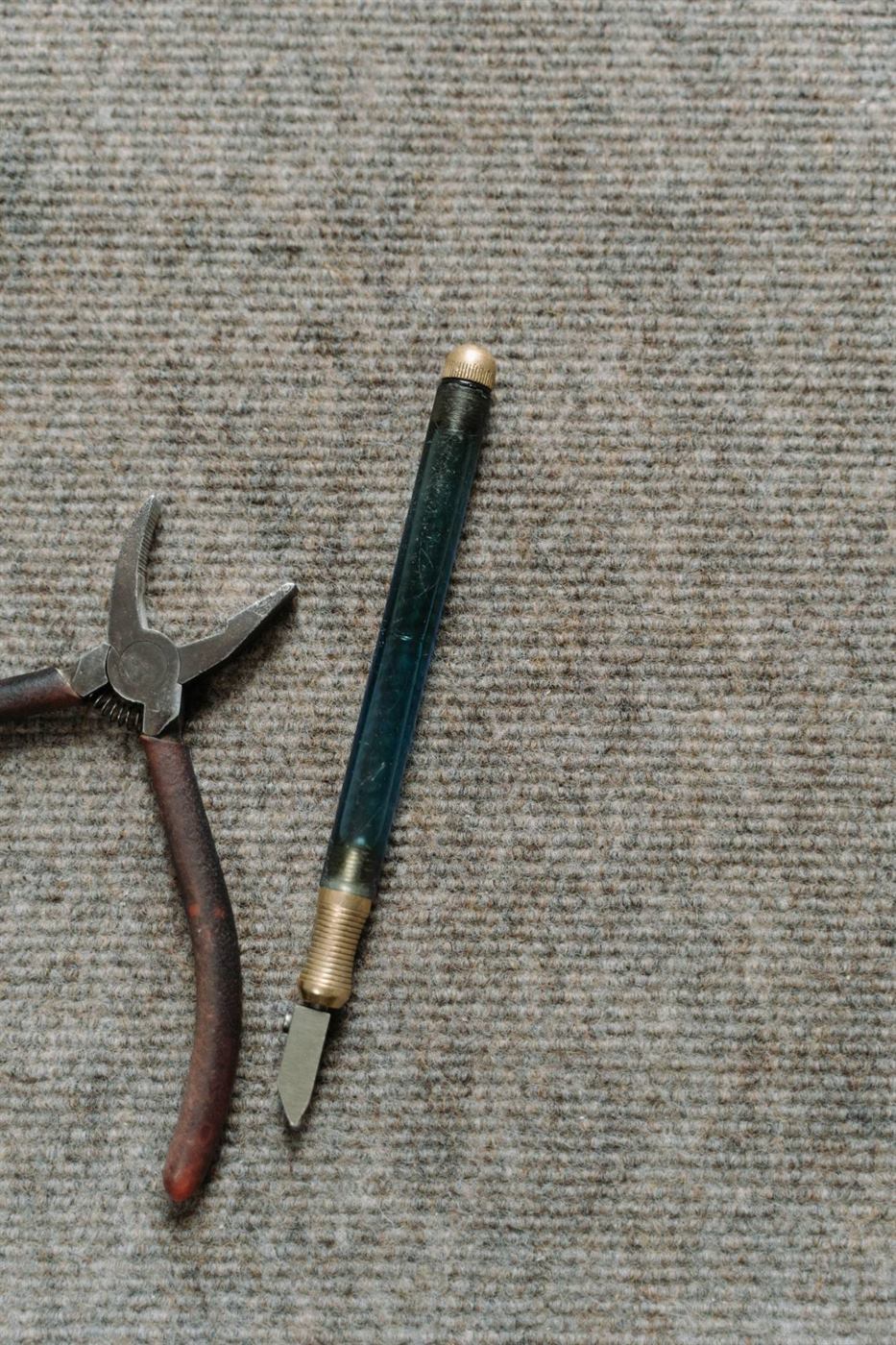 Carpet repair hand tools laid out on a berber carpet