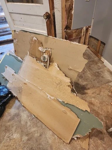 Water-damaged drywall removed and stacked during a restoration